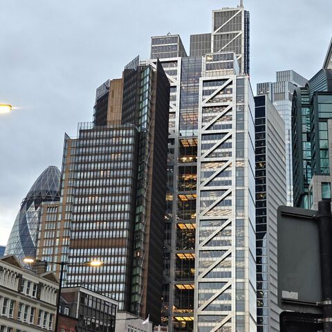 The City of London skyline at dusk, the Gherkin and Heron Tower lit from within.