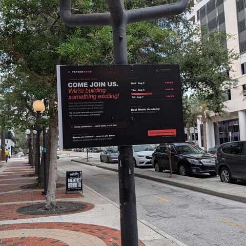 The FetishHaus session board mounted on a lamp post in downtown St. Petersburg, listing all three showings.